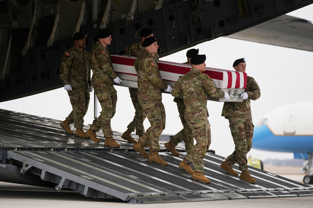An Army carry team moves a flag-draped transfer case with the remains of Sgt. Declan Coady, 20, of West Des Moines, Iowa