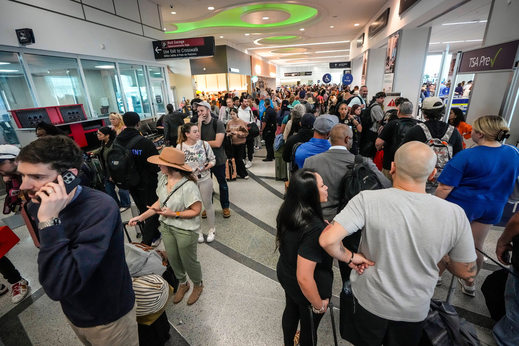 Airline passengers wait in long lines to get through the TSA security screening 