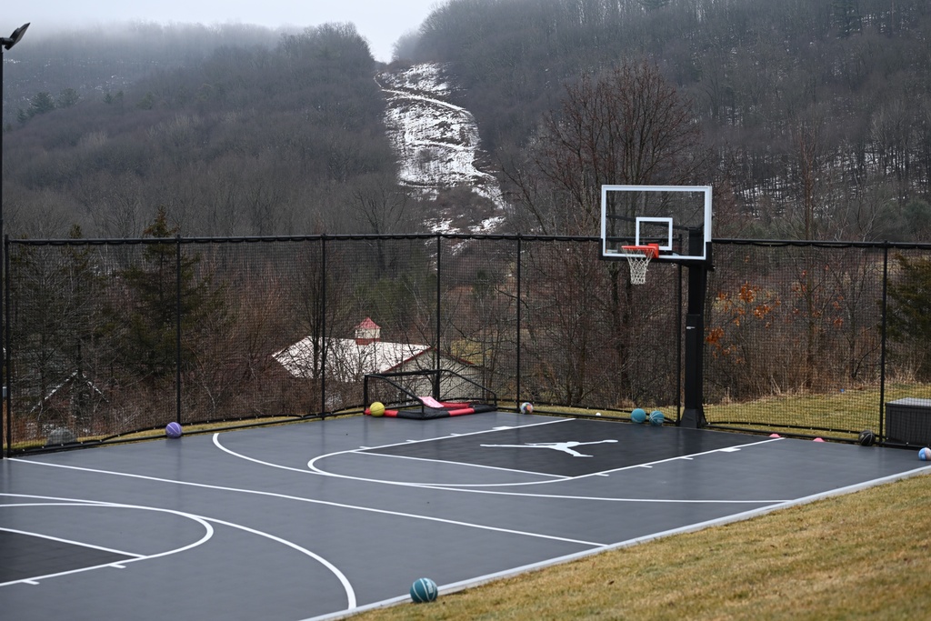 The snow-covered corridor once used for a since-removed residential power line is visible behind the basketball court and barn on John Zola