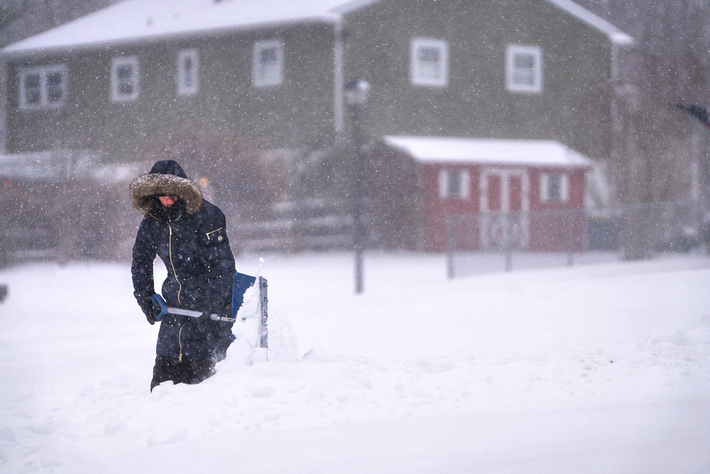 Maryann Slovin begins clearing out her driveway and sidewalk in Hockessin, Del.