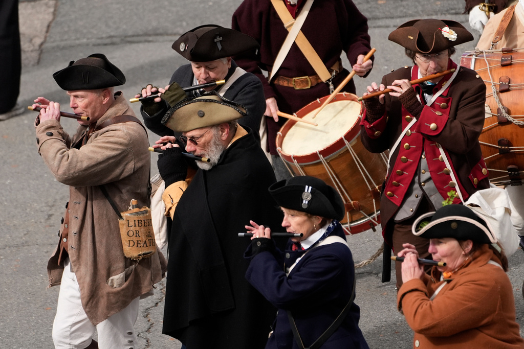 Members of a fife and drum band march in a procession during an Evacuation Day ceremony 