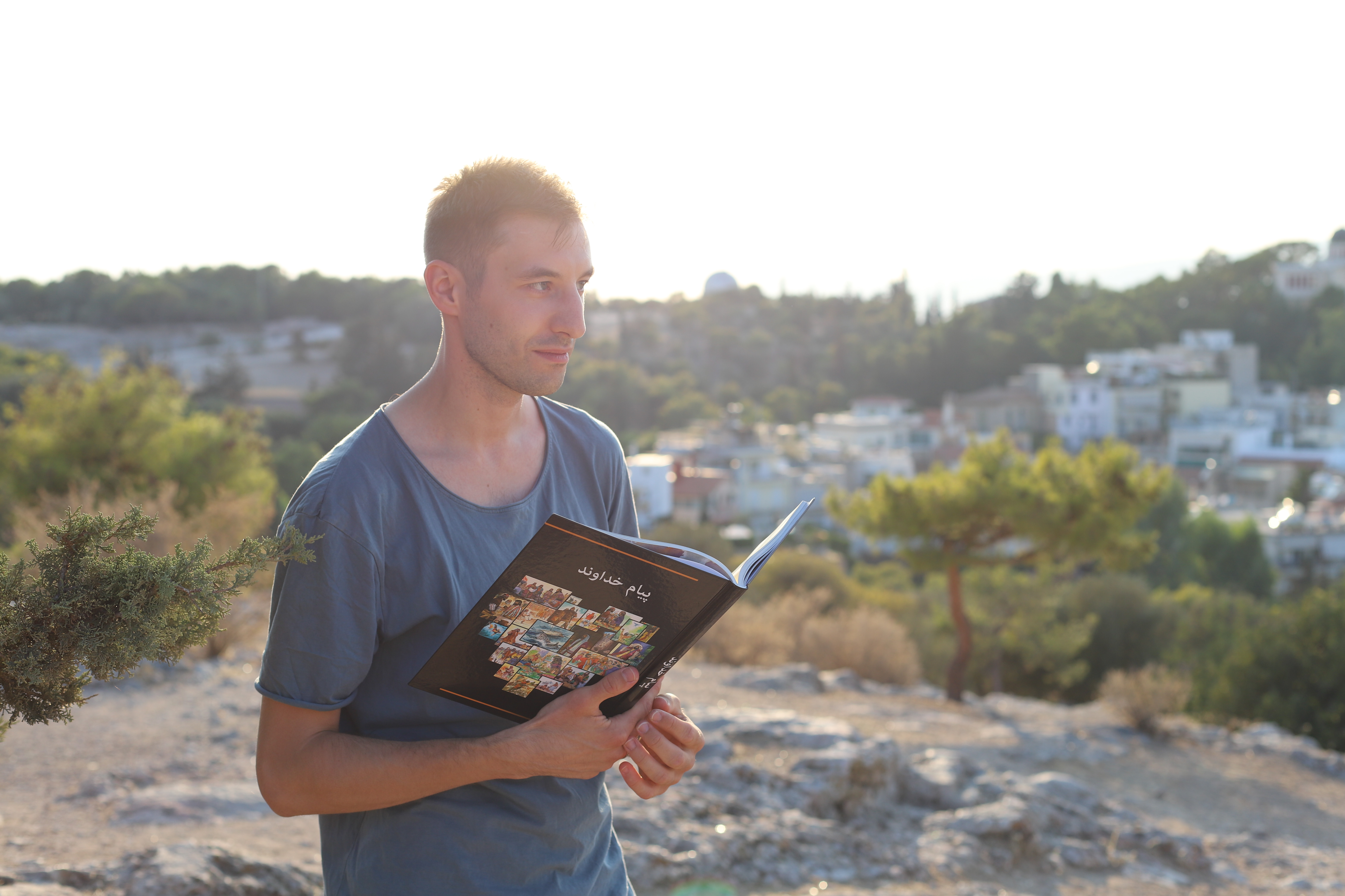 EEM worker with book about biblical accounts in Farsi