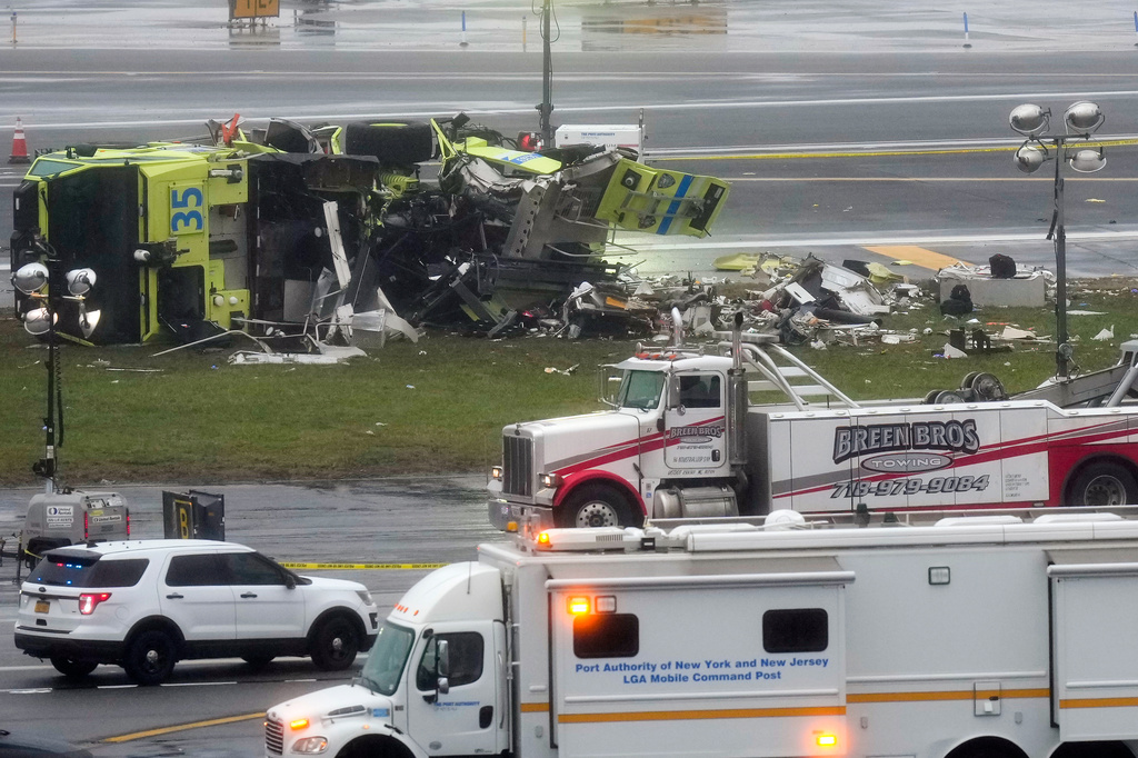 A Port Authority firetruck lays on its side just off the runway at LaGuardia Airport