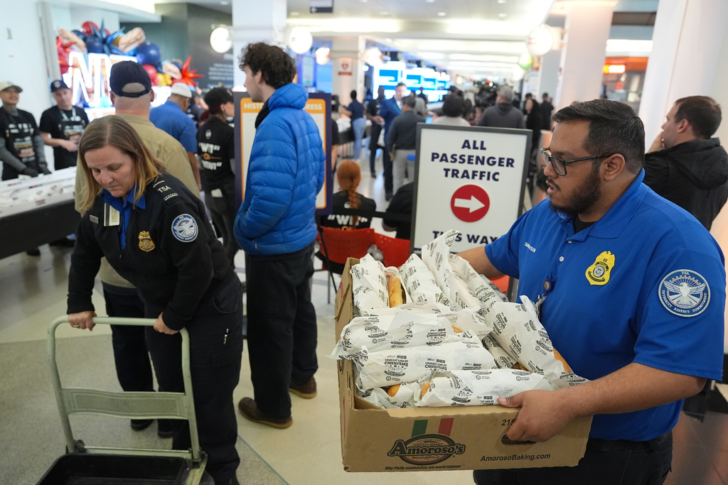 Transportation Security Administration (TSA) workers collect cheesesteaks for their coworkers that were made for a Guinness World Record attempt 
