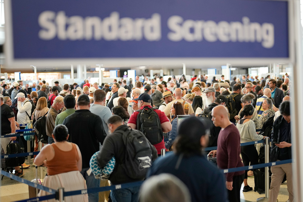 Passengers wait in a security checkpoint 