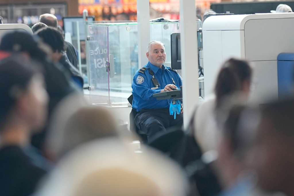 Passengers and their bags are screened at a security checkpoint at George Bush Intercontinental Airport