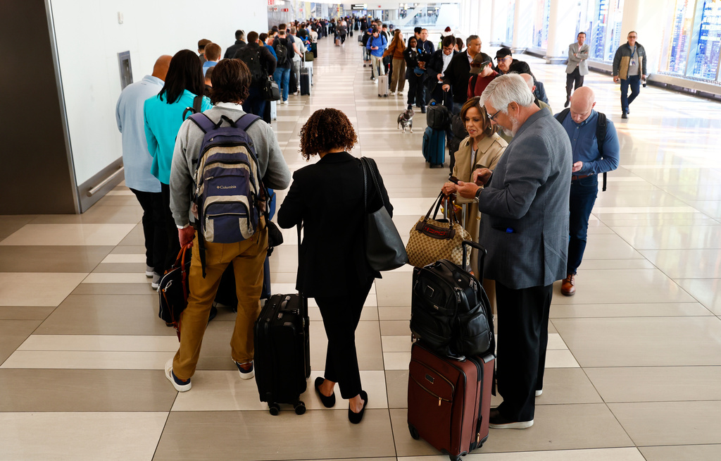Passengers stand in the TSA pre-check line at LaGuardia Airport