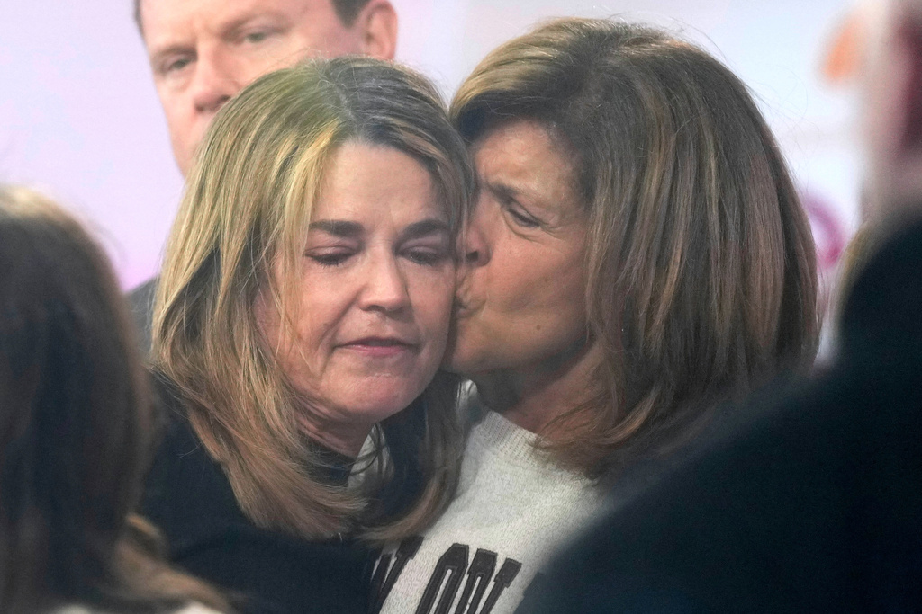 Savannah Guthrie, left, gets a kiss form Hoda Kotb during a visit to the Today show at Rockefeller Plaza 