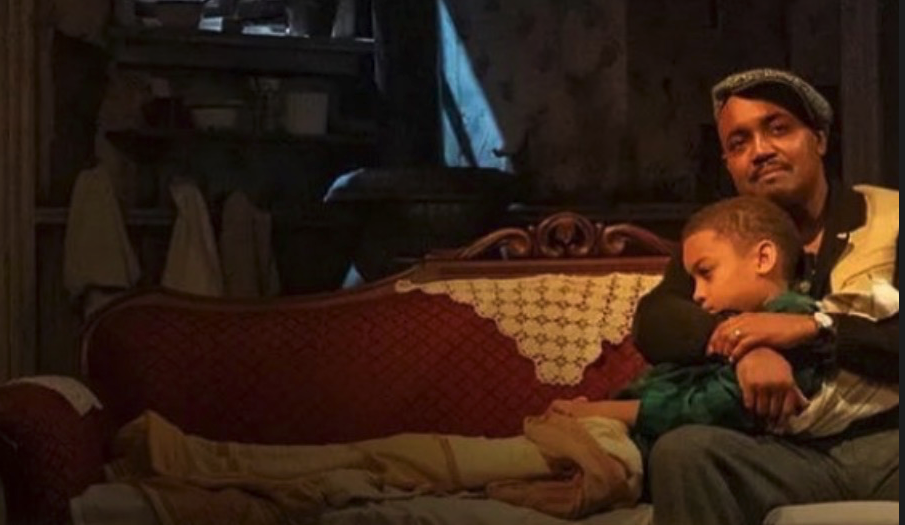 Father and son on a couch on set of a play