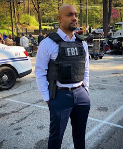 Man with FBI flak jacket on set of TV show