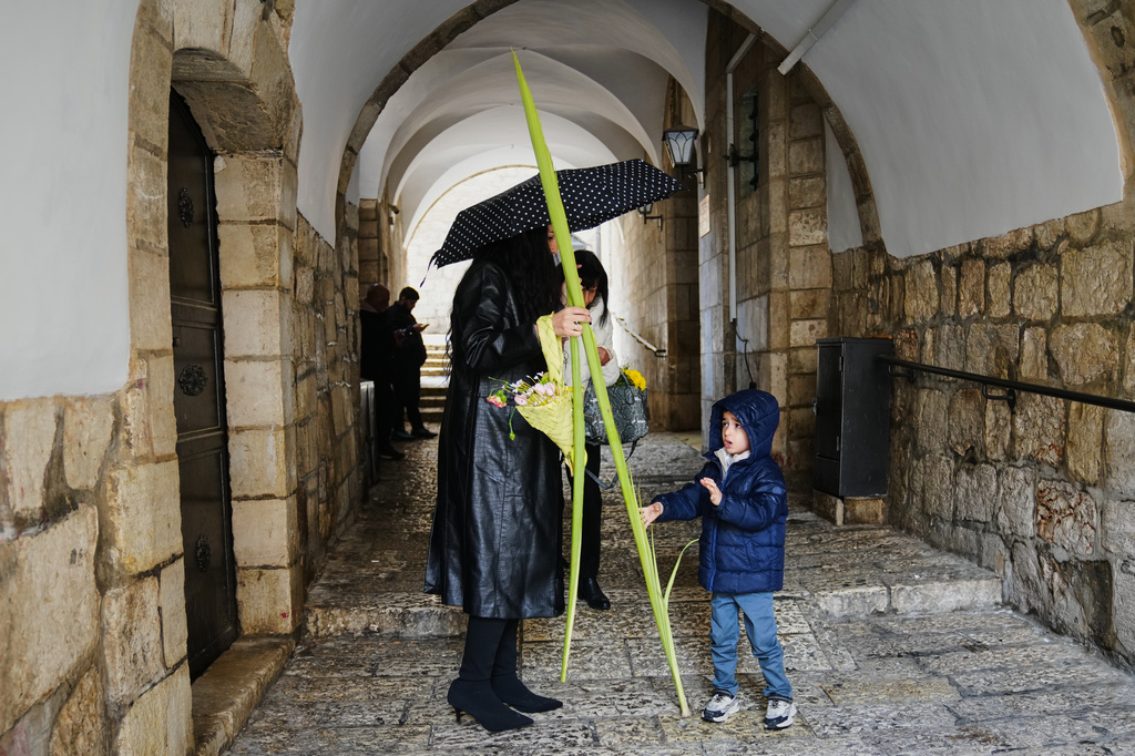 Christians walk with palm branches during Palm Sunday in Jerusalem