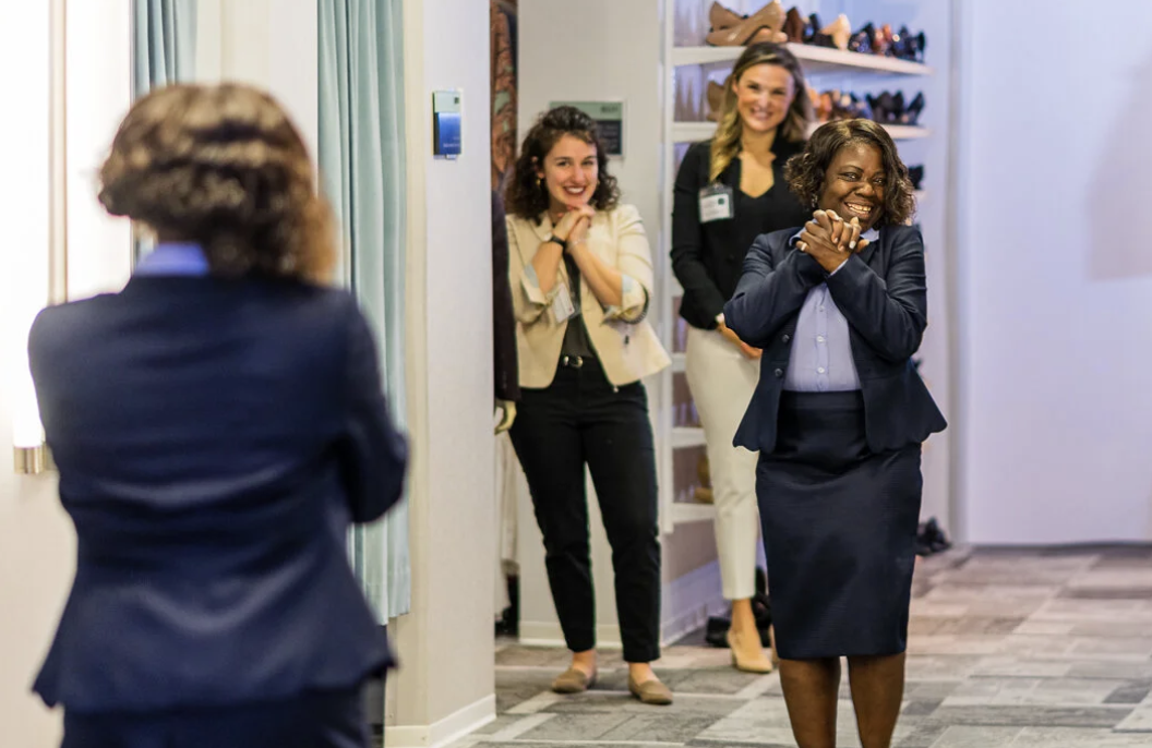 Woman excited to see herself in the mirror with a suit