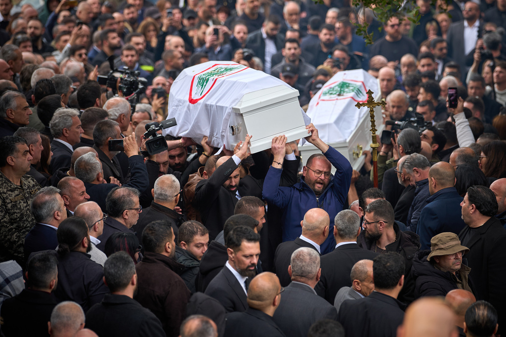 Men carry the coffins with the bodies of Pierre Mouawad, an official with the anti-Hezbollah Lebanese Forces party, and his wife during their funeral in Yahshush, Lebanon