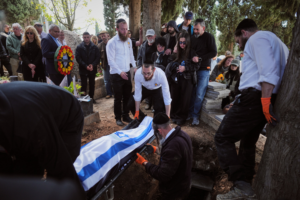 Israeli mourners carry the flag-draped bodies of three members of the Gershovich family, killed when an Iranian missile struck their building