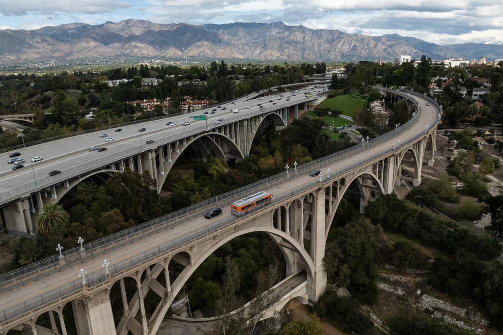 Motorists cross the historic Colorado Street Bridge in the foreground, a Route 66 landmark in Pasadena, Calif.