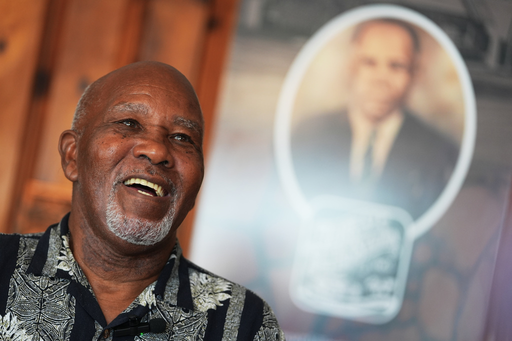 Edward Threatt, speaking in front of a photograph of his grandfather Allen Threatt Sr., is interviewed at the Threatt Filling Station along Route 66 in Luther, Okla.