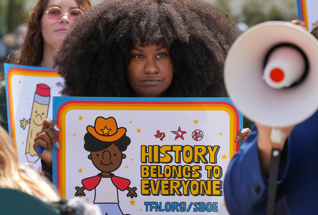 Taylor Crawford of Houston holds a sign reading "History belongs to everyone" during a rally on the Capitol Mall