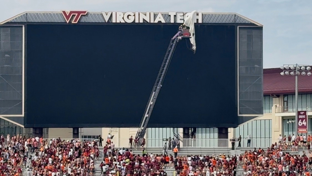 Video footage showed the skydiver’s parachute landing between the “C” and the “H” on the Virginia Tech lettering on top of the scoreboard 