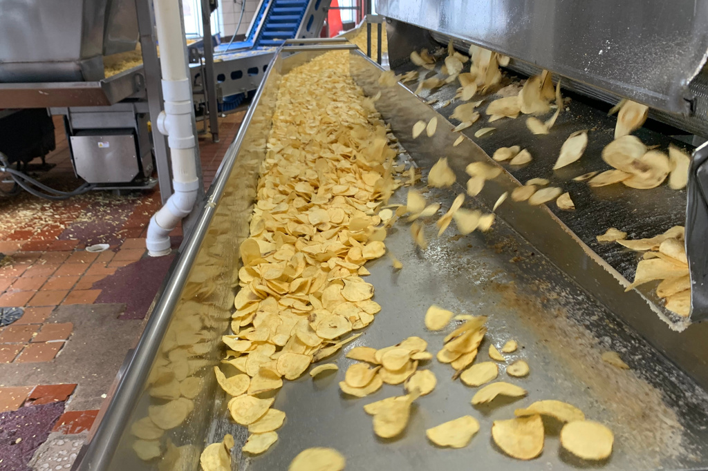 Potato chips move along a conveyor at a Better Made Snack Foods processing facility in Detroit