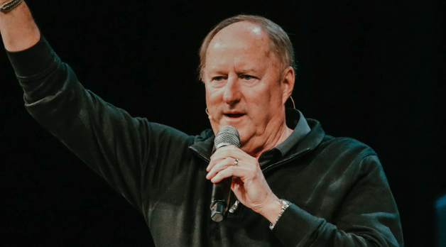 Man raising hand in the hair with microphone in hand