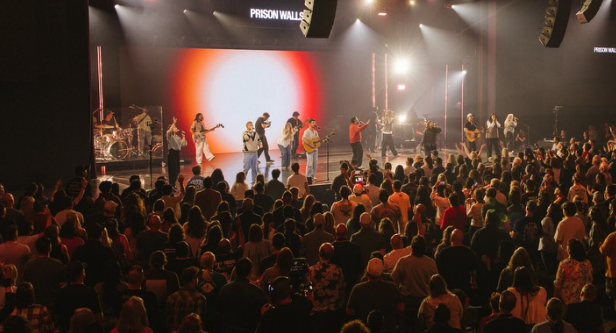 Crowd of people surrounding a stage with musicians