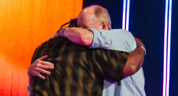 Two men hugging on stage
