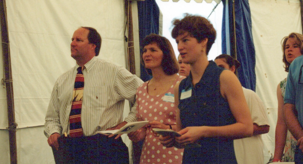Three people worshipping in a tent