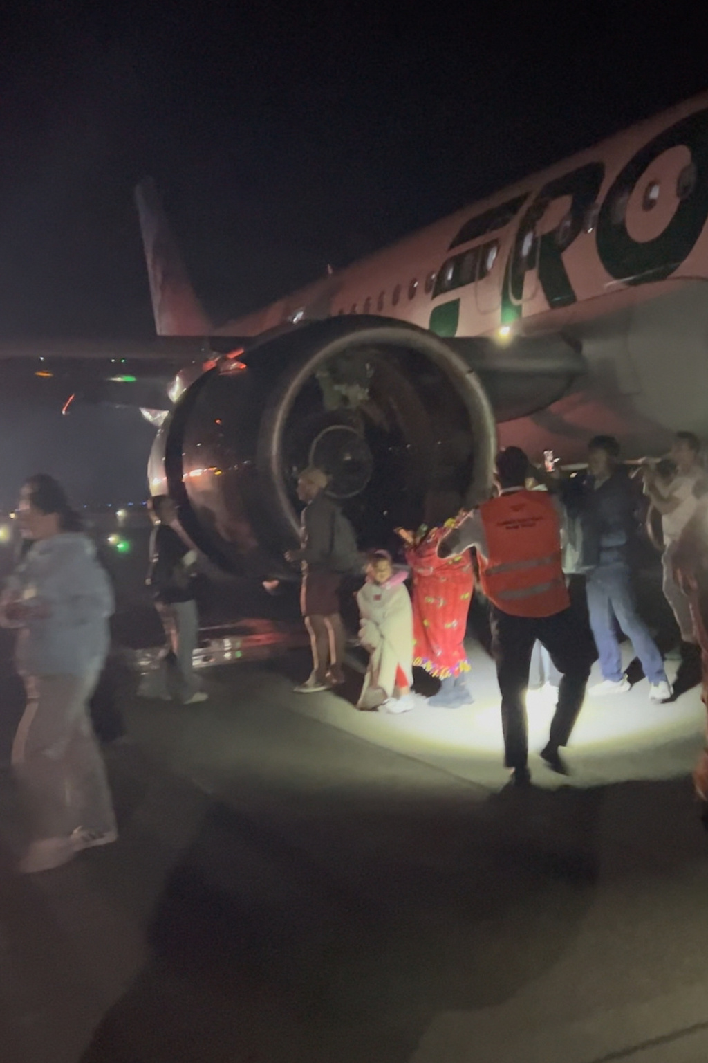 Passengers evacuate a airplane after a person was struck and killed by a Frontier Airlines plane during takeoff, at Denver International Airport