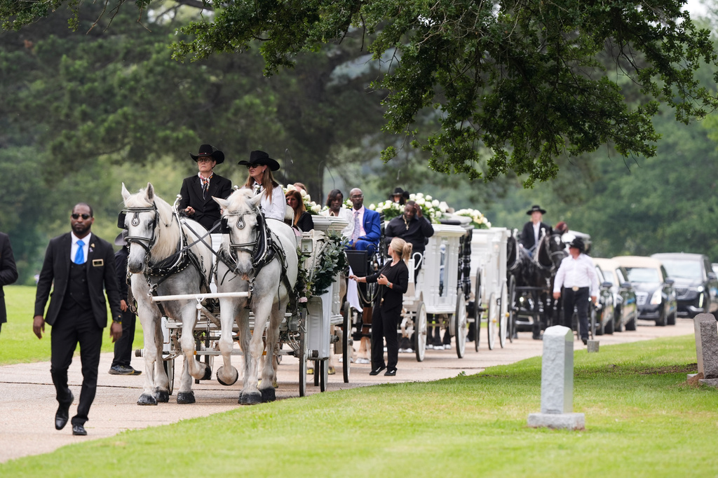 Caissons carry the caskets of eight children 