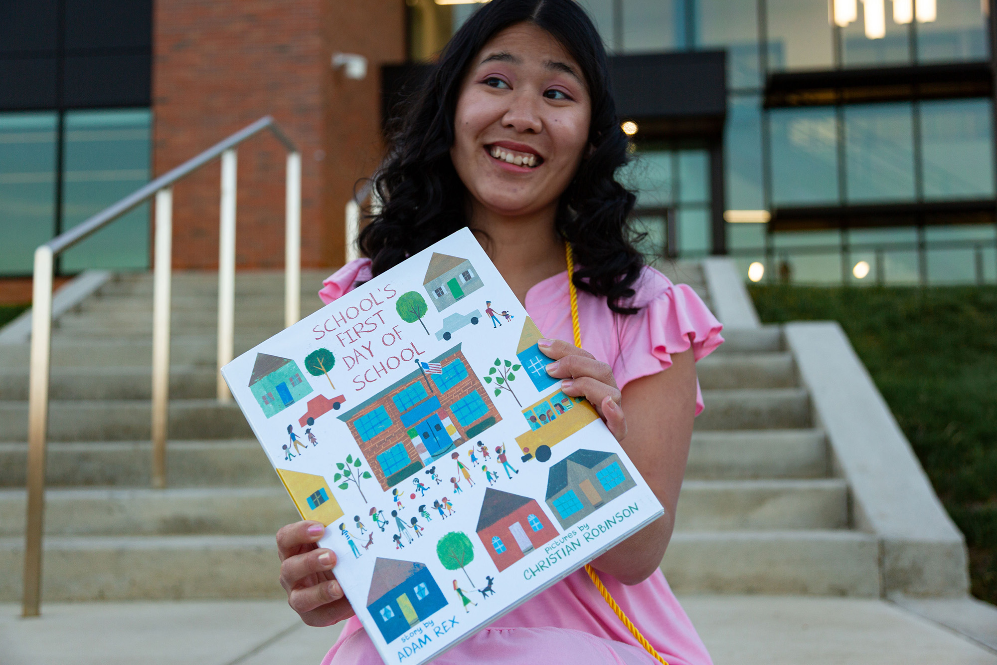 Olivia “Ms. L” Luckhaupt holds a children’s book outside a school building as she prepares for a career in special education. 