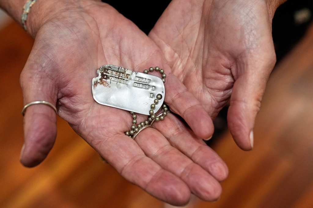 Diane Christie holds a recovered dog tag belonging to her uncle, World War II U.S. Army Air Forces 2nd Lt. Thomas Kelly