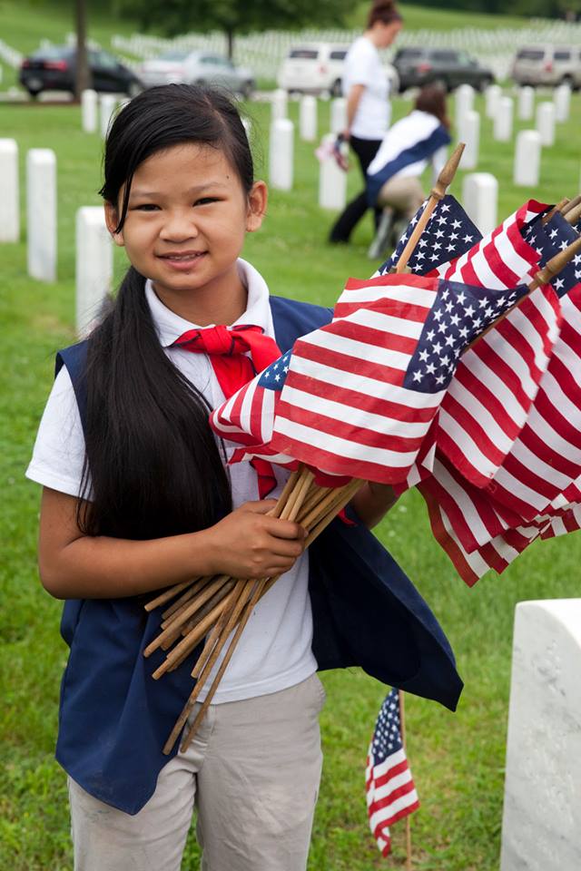 girl with American flags at cemetery