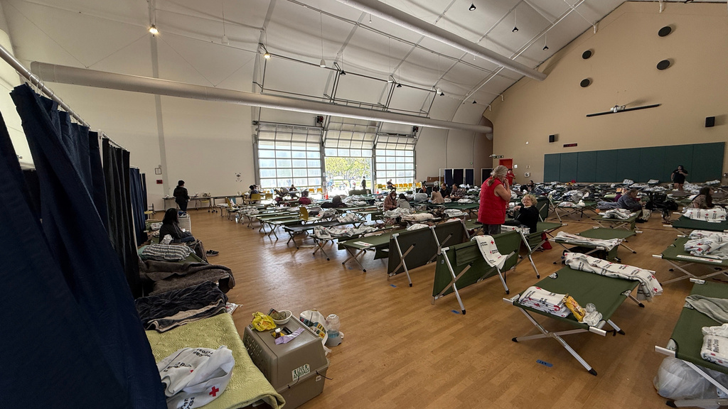 People arrive at Freedom Hall, an evacuation center in Fountain Valley, Calif.