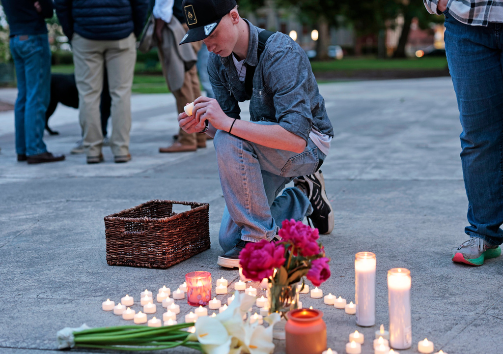 Kaeden Beck, 16, lays down electric candles during an evening prayer and vigil, in support for the victims and their families impacted by Nippon Dynawave Packaging Co. tank implosion