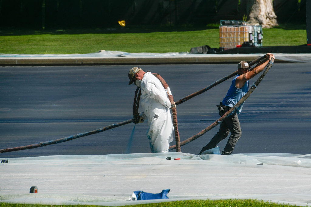 Work continues on the Lincoln Memorial Reflecting Pool, which is covered in a blue coating, ahead of the United States 250th anniversary