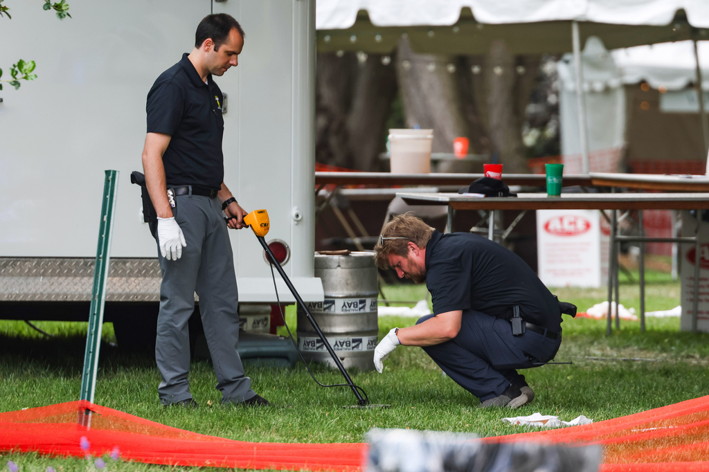 Investigators use a metal detector to look for shells after a shooting