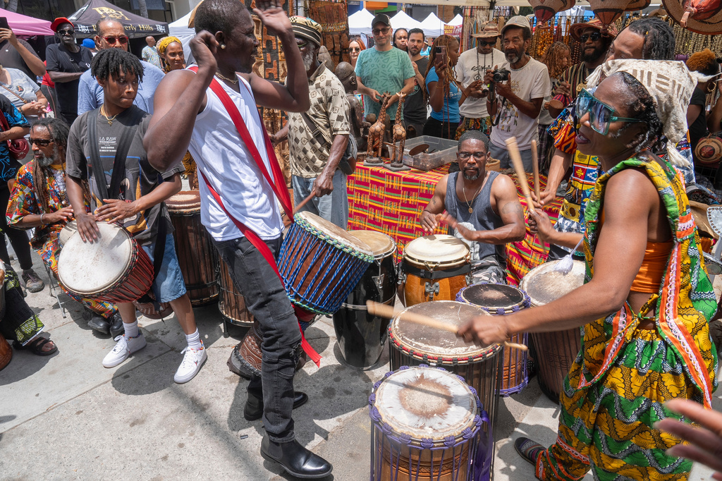 Drummers form a circle around Sika Dwimfo, better known as the, "Godfather of Leimert Park," during the neighborhood