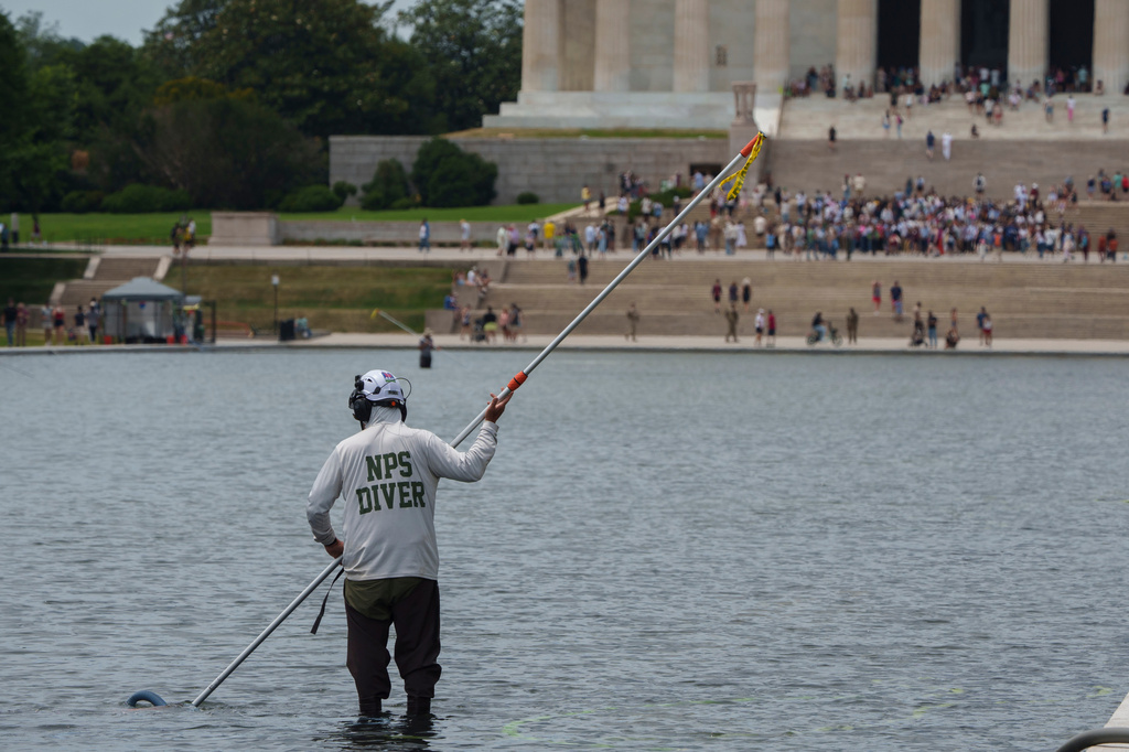 A National Park Service employee works to clean the Lincoln Memorial Reflecting Pool 