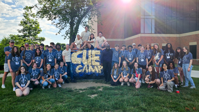 Students who participated in the third annual Cedarville Entrepreneurship camp at Cedarville University stand next to "The Rock," which is a student landmark on campus.