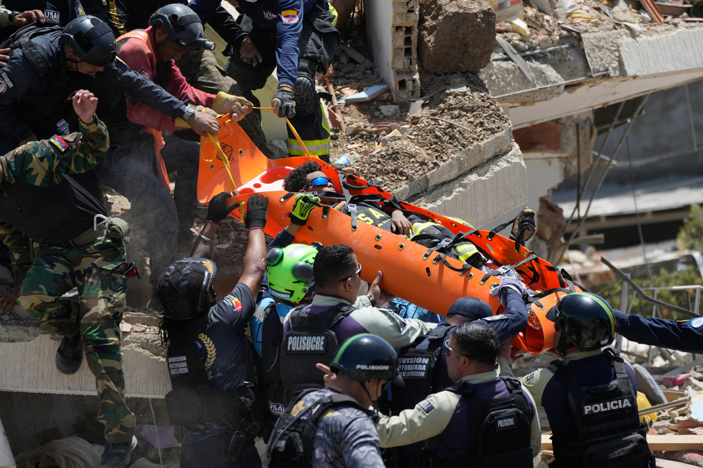 Rescue workers pull Moises Calzadilla, 11, from the rubble three days after earthquakes struck La Guaira, Venezuela