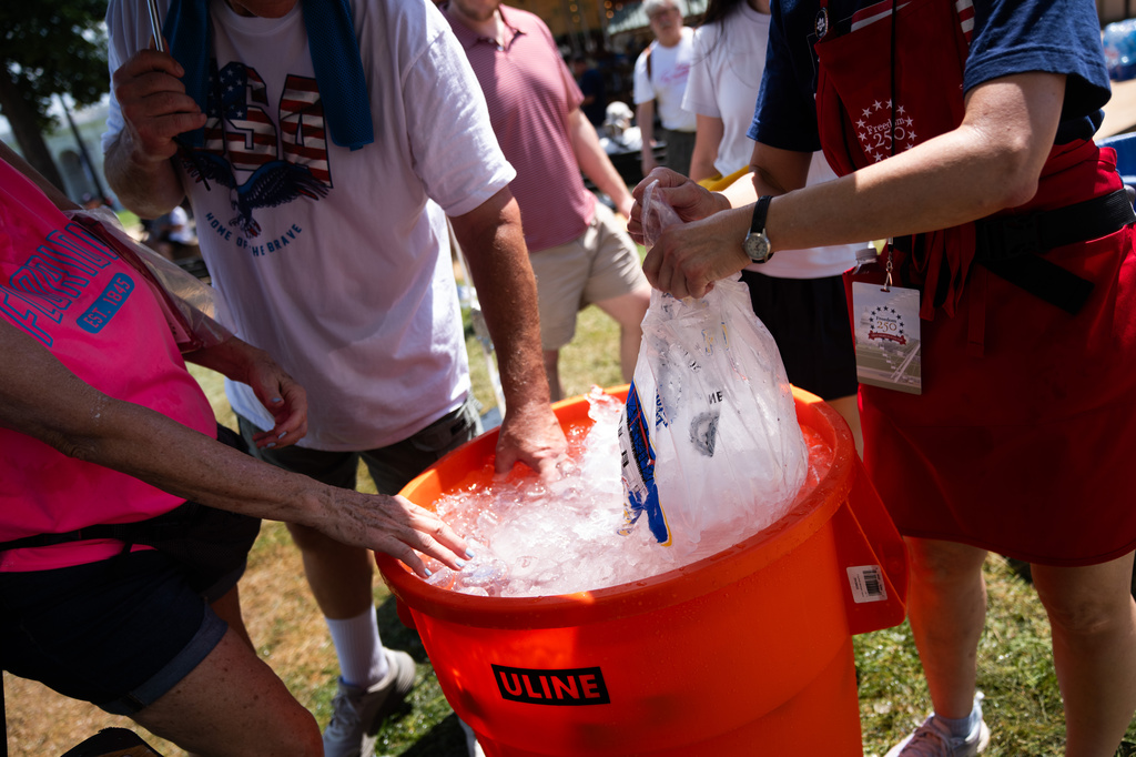 Attendees dip their hands in ice water at the Great American State Fair on the National Mall
