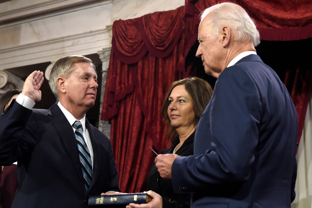 Vice President Joe Biden, right, administers the Senate oath to Sen. Lindsey Graham, R-S.C., left, as Graham