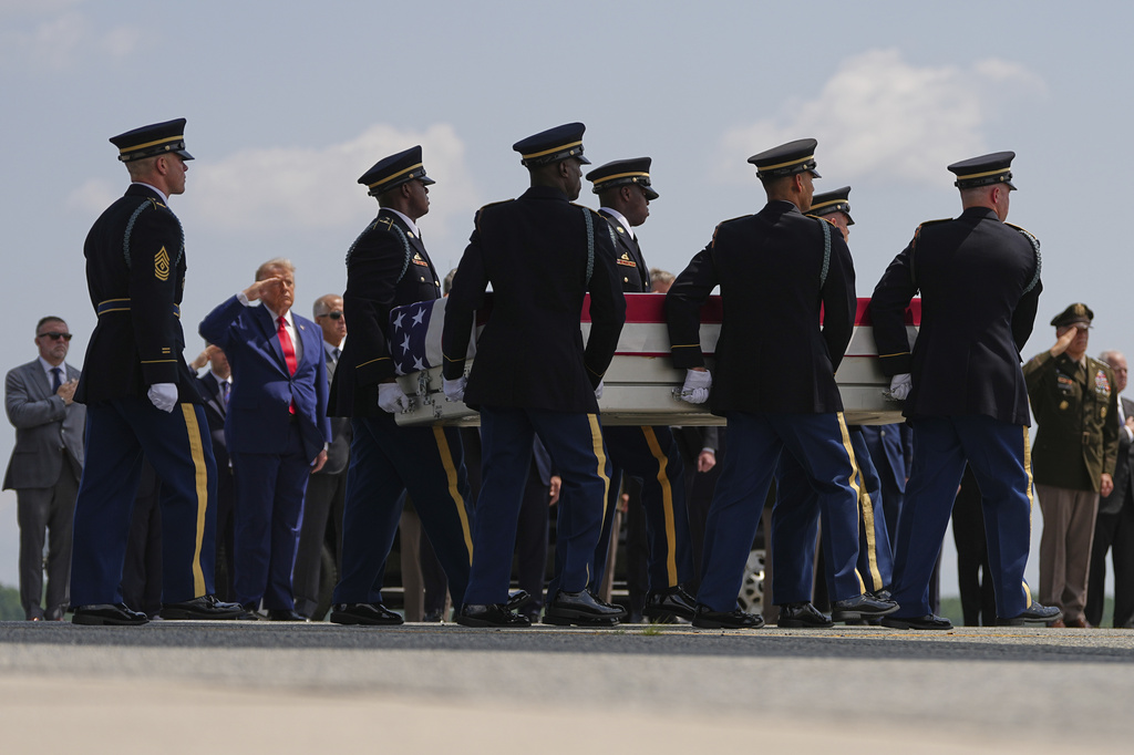 President Donald Trump salutes as a U.S. Army carry team moves a transfer case containing the remains of Pvt. Isabella Gonzales