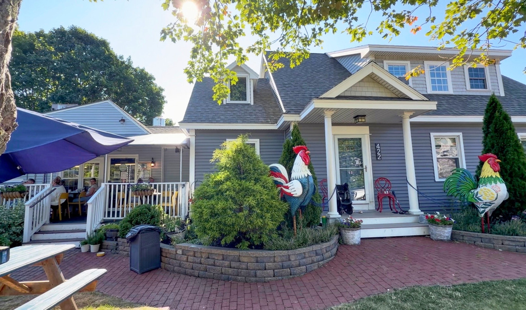 Large tin roosters decorate the entrance to the home of David and Sarah Leblanc, which is attached to their breakfast restaurant, The Omelette Factory, at left