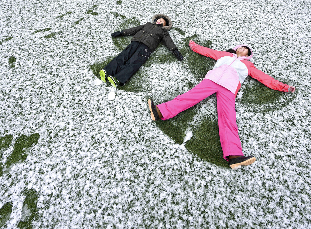 Jacob Polanco, left, 8, and his older sister Khloe, 9, make snow angels after snow fell in their neighborhood at approximately the 1,400 foot level in Rancho Cucamonga, Calif., on Saturday, Feb. 25, 2023.