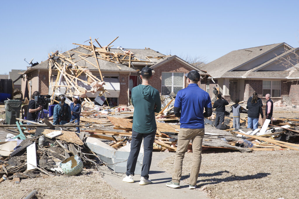Neighbors look at damage to homes along Frost Lane in Norman, Okla.