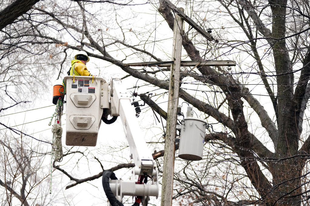 A DTE contractor crew works on a power line in northwest Detroit