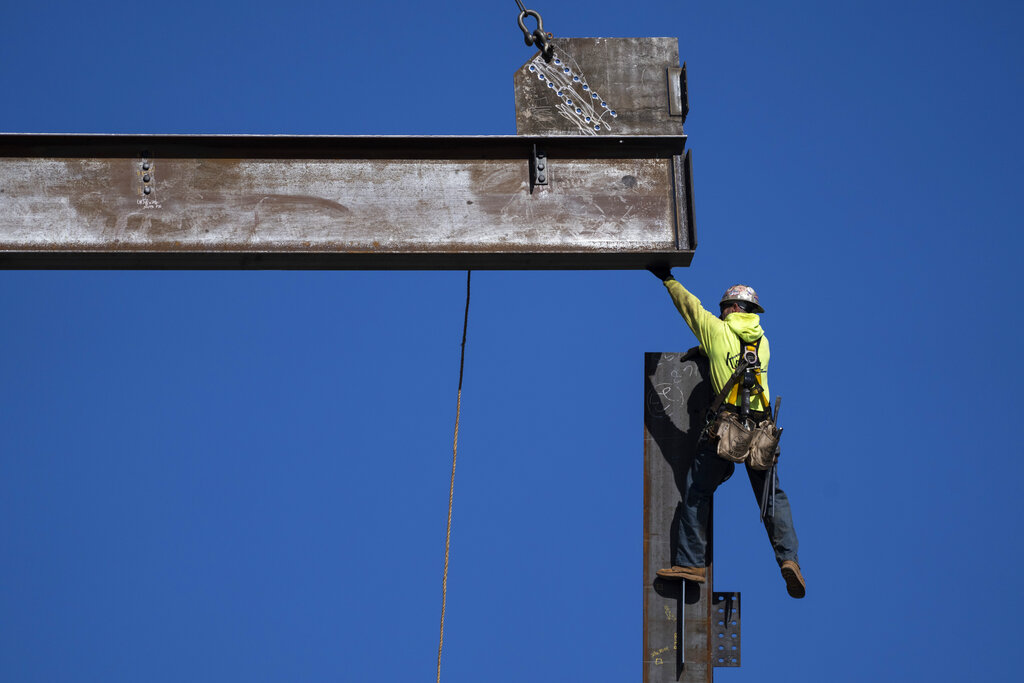 An ironworker guides a beam during construction of a municipal building in Norristown, Pa.