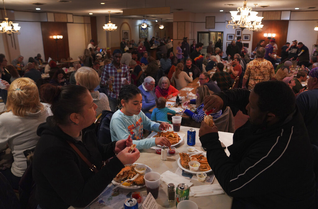 Valerie Mozes, left, Seveyah Mozes, 9, center, and John Oliver, eat a fish dinner on the first night of Lent at the Allegheny Elks Lodge #339 in Pittsburgh