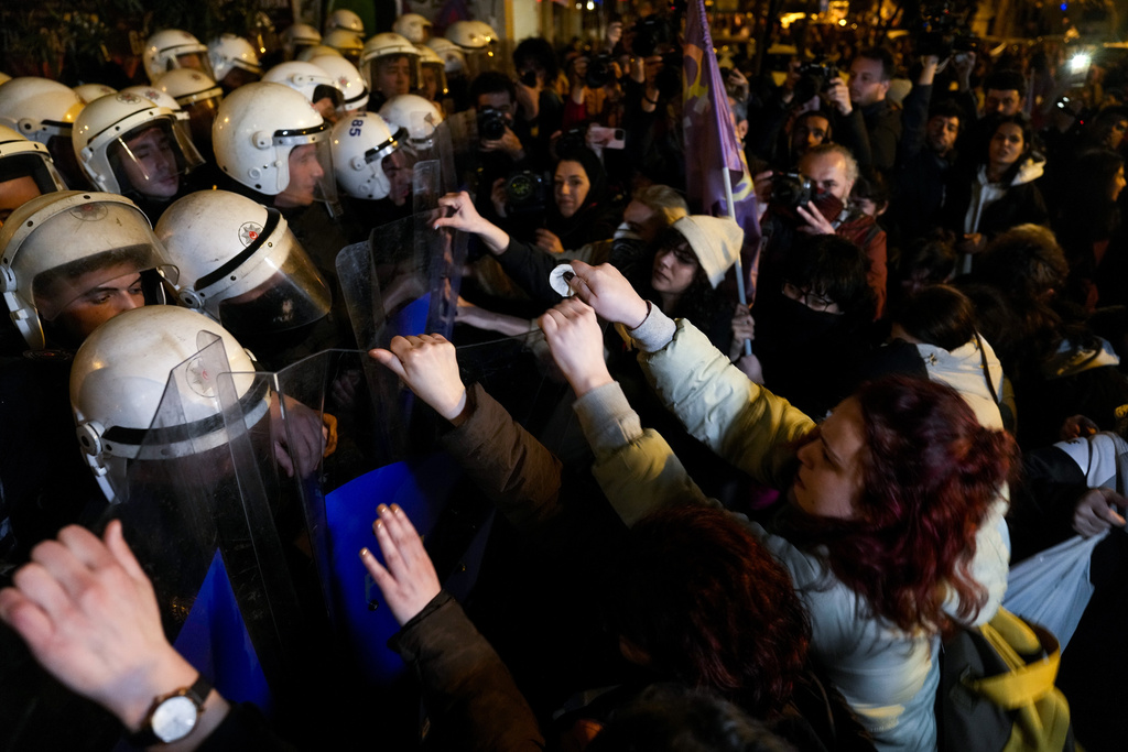 Protesters scuffle with anti riot policemen at the end of the gathering to mark the International Women